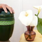 Cremation urn beside flowers in a vase