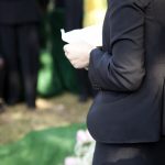 Person reading a piece of paper during a graveside service