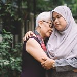 A young woman hugging an older woman, helping her cope with the loss of a loved one