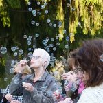 A woman blows bubbles at Woodlawn Memorial Park's in-person event.