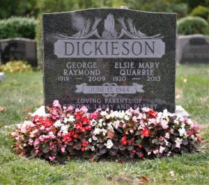 Grave stone with flowers around it in the summer