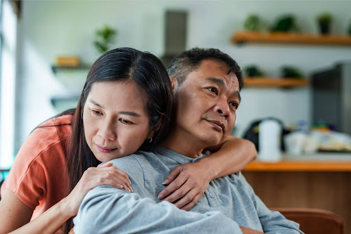 Woman hugging man to console him.